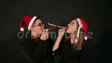 一对戴着圣诞帽的夫妇的肖像，在新年里吹着口哨。